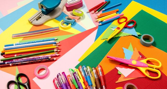 Bright coloured craft materials including papers, pens and scissors.